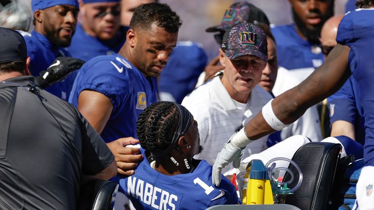 Teammates and trainers tend to New York Giants wide receiver Malik Nabers (1) after an injury during the second quarter of an NFL football g