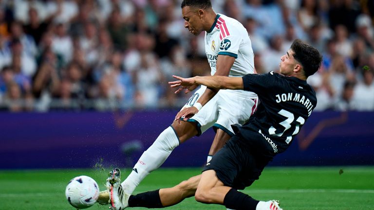 Jon Martin of Real Sociedad tackles Kylian Mbappe of Real Madrid
